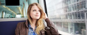 Young woman sitting on a bus and thinking about credit score ranges