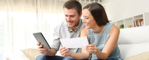 Happy couple checking their credit scores on a tablet