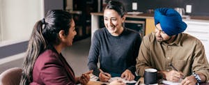 Couple sits with financial advisor to go over papers