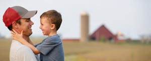 Father and son hug each other on their family farm