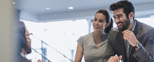Man and woman talk to a receptionist at a desk