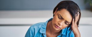 Woman looking stressed with her head in her hand