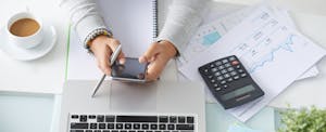 person using their smart phone at a desk