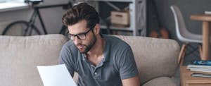 un hombre mira el papeleo tratando de entender sus opciones porque no tiene un puntaje de crédito