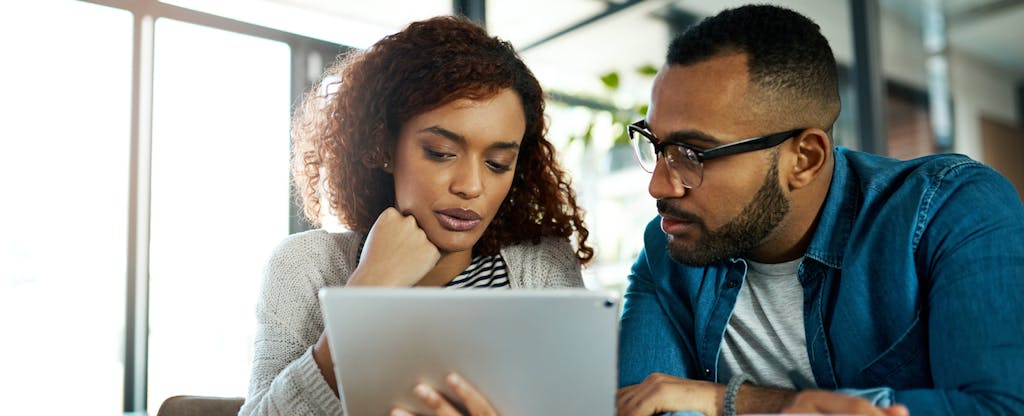 Young couple using a digital tablet to look up what is a jumbo loan