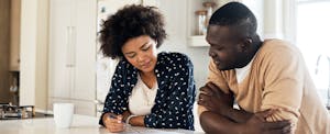 Couple sitting at kitchen table, researching an Interfirst Mortgage