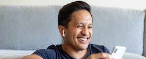 Man sitting at home, reading on his cell phone about Movement mortgages