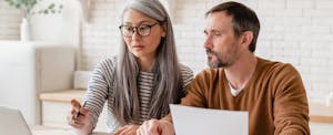 Mature couple reviewing loan documents together.