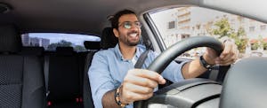 Man smiling as he's driving his car