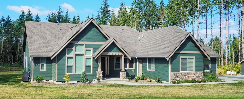 Photo of a teal house with trees in the background